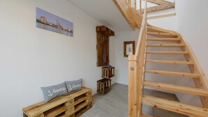 En trætrappe fører op til et soveværelse på loftet med udsigt over bybilledet.