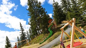 A playground with a slide, swings, and a climbing structure. - Doppelzimmer Smartcomfort - Smarthotel & Smartflats - Dein Basecamp in Gastein (Dorfgastein)