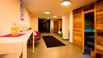 A hotel lobby with a reception desk, chairs, a black rug, wooden walls, and a staircase.