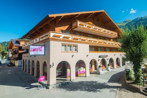 Hotel amb un rètol ben visible, un balcó i vista a la muntanya.