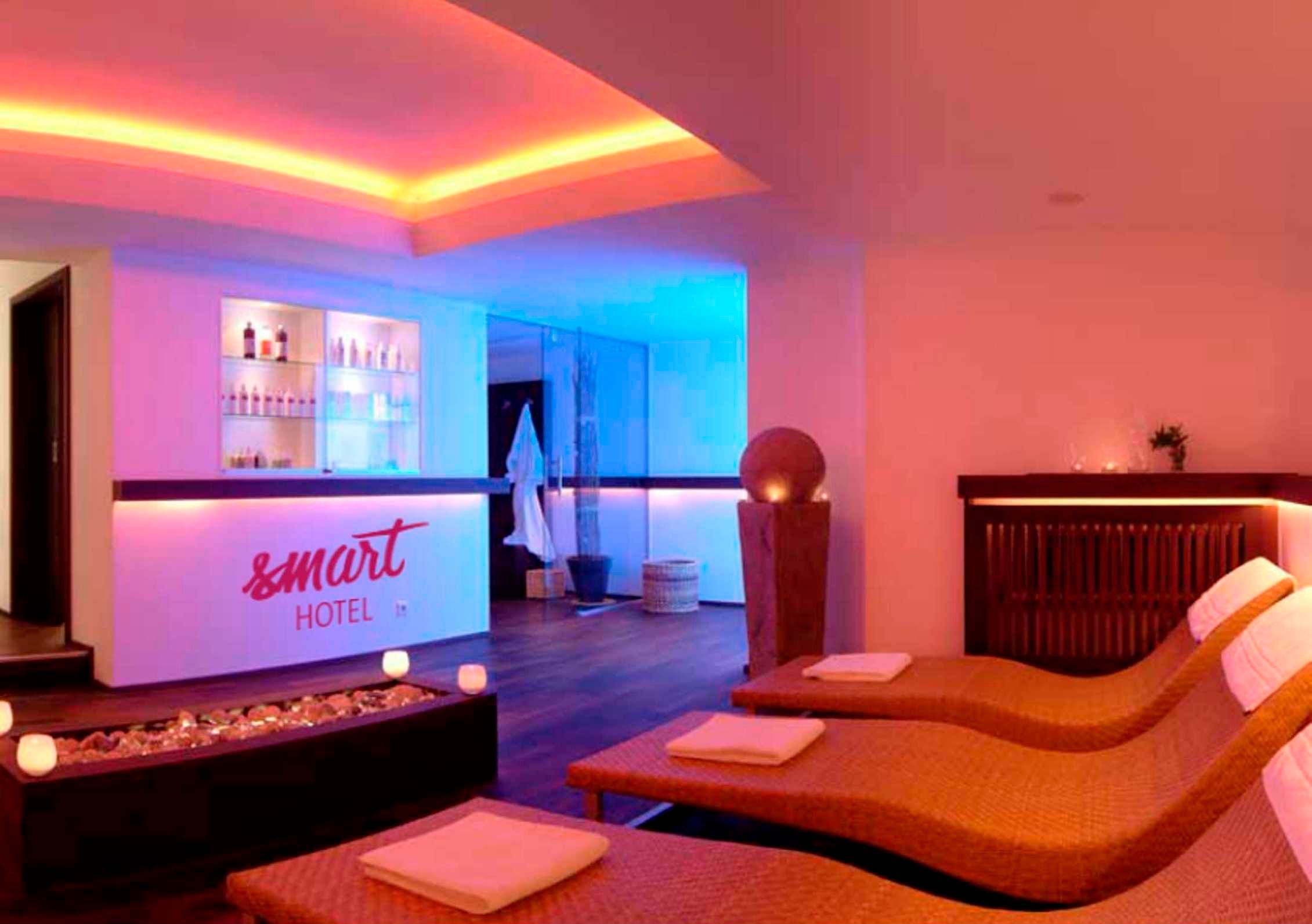 Eine Hotlellobby mit Empfangsbereich, Bar und einem Massagezimmer mit zwei Massagetischen.