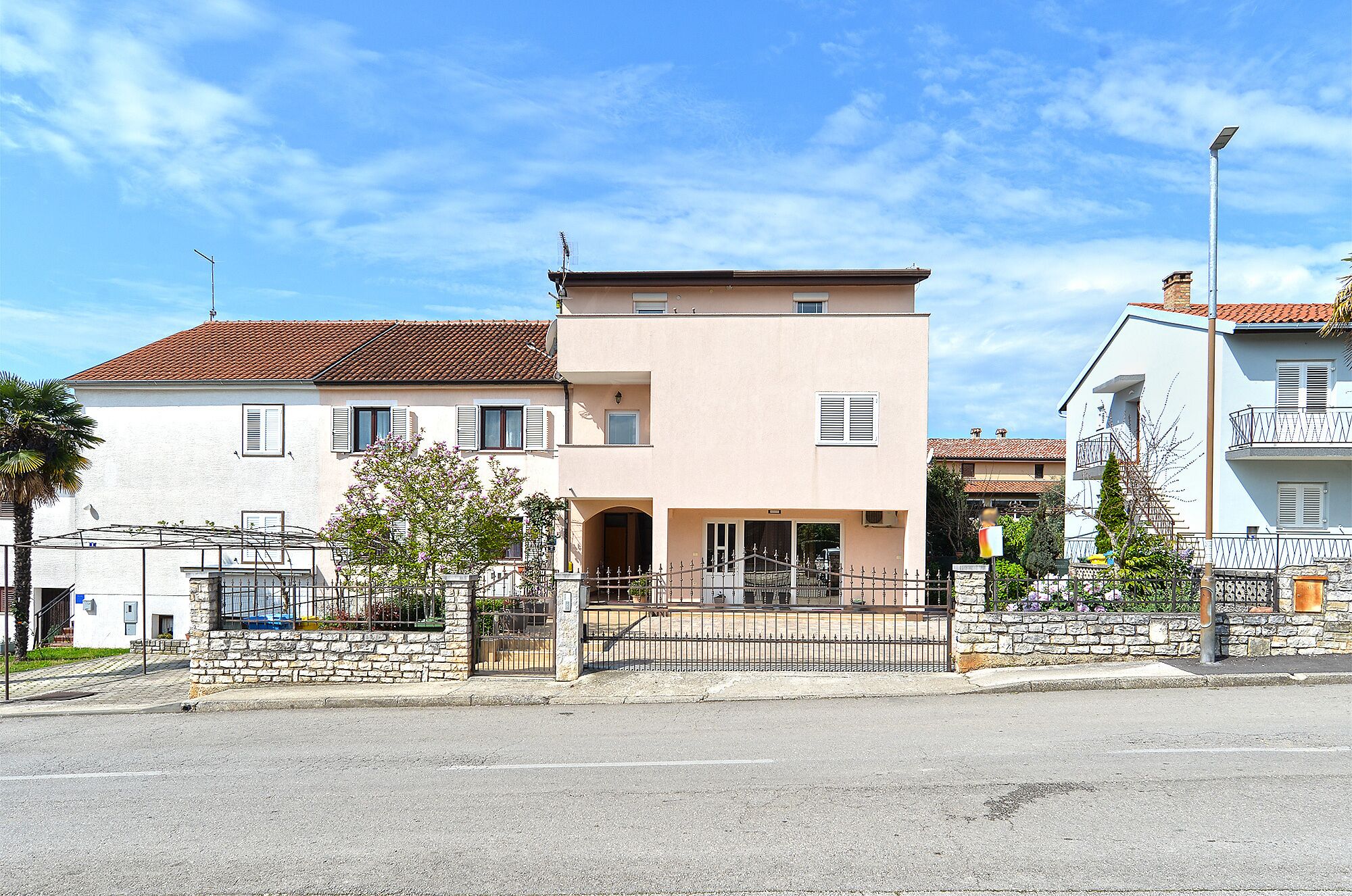A two-story building with a flat roof and a balcony on the second floor.