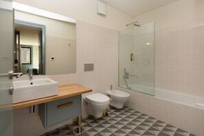 A modern bathroom with a sink, toilet, bidet, and glass-enclosed shower. - Feel Corporate Housing Campanhã 03 (Oporto)