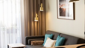 Een moderne woonkamer met een bank, een bijzettafeltje en een ingelijste foto aan de muur.