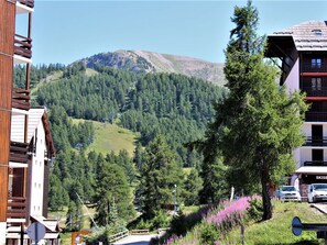 A mountain view with a ski resort, including buildings and a parking area.