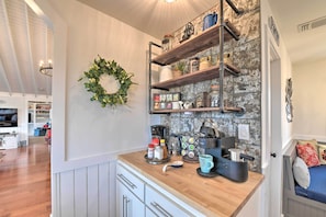 Kitchen area with sink and wooden shelves, offering a comfortable and open layout.