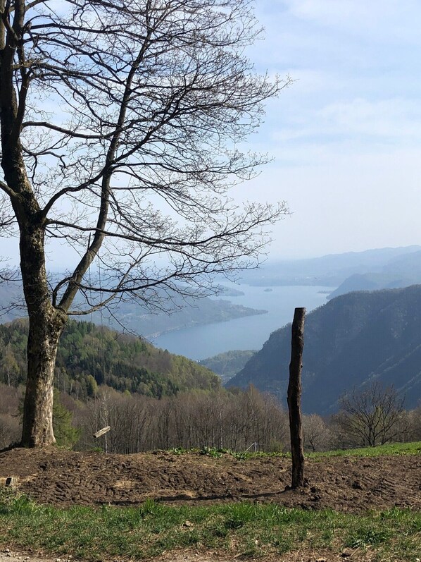 Surrounded by a serene valley and a distant body of water, this tranquil landscape offers a peaceful escape.
