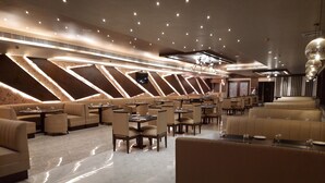 A modern restaurant with high ceilings, recessed lighting, and a mix of booth and table seating. - Jay Clarks Exotica (Nahan)