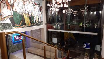 A modern interior with a staircase, a mural, and hanging lights.