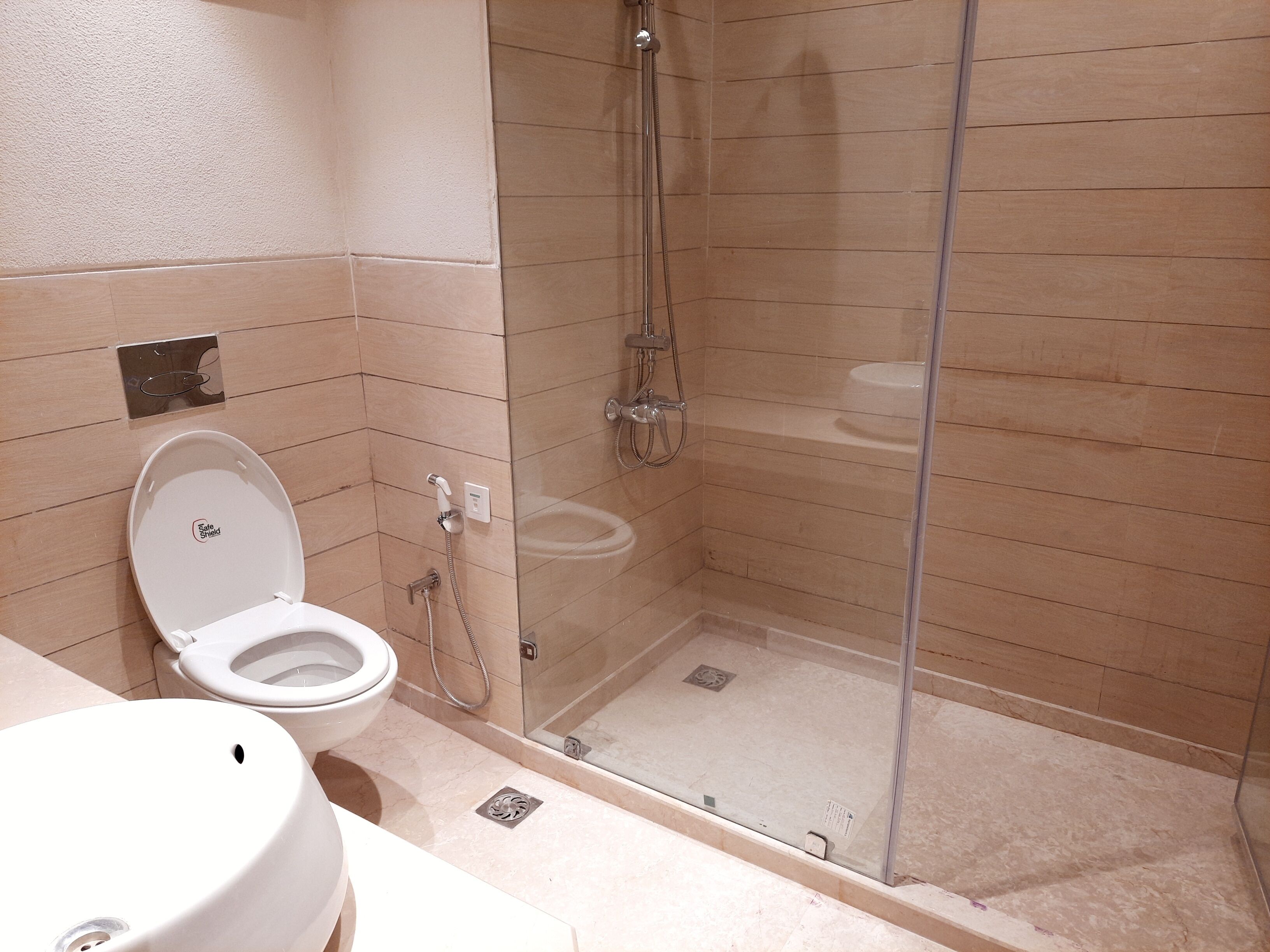 A bathroom with a toilet, sink, and a glass-enclosed shower area.