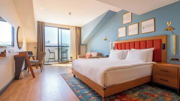 Una habitación de hotel moderna con una cama grande, un escritorio y un balcón.