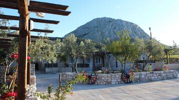 Situated in a serene landscaped area, this traditional building features a stone facade and a pitched roof.