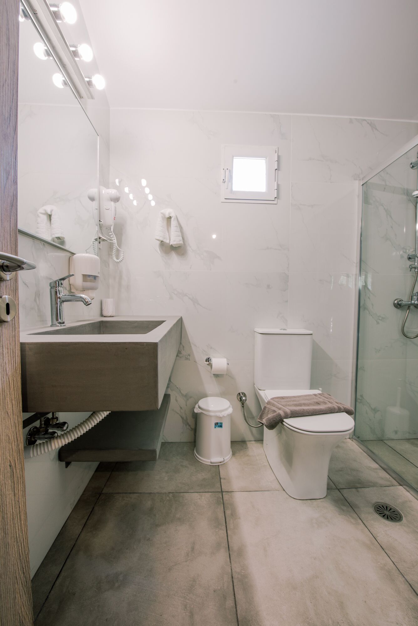 A modern bathroom with a vanity, toilet, and shower.