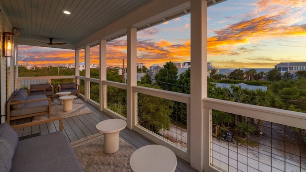 A covered outdoor seating area with a view of a sunset over a residential neighborhood. - PRIVATE  POOL! 6 SEAT GOLF CART!  VOLLEYBALL COURT! 2 MIN. WALK TO BEACH! (Santa Rosa Beach)