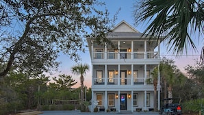 A two-story building with a balcony on the upper floor, a driveway, and a golf cart parked in front. - PRIVATE  POOL! 6 SEAT GOLF CART!  VOLLEYBALL COURT! 2 MIN. WALK TO BEACH! (Santa Rosa Beach)