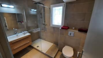 Een douche, een haardroger, handdoeken, toiletpapier