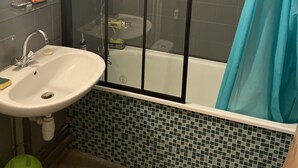 Un baño con ducha envuelta en vidrio, lavabo y bañera.