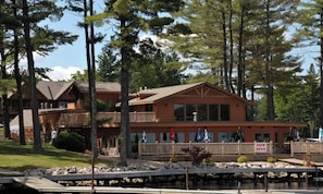 Un chalet doté d’une jetée, d’une façade en bois et d’une enseigne indiquant « OUVERT MAINTENANT ».