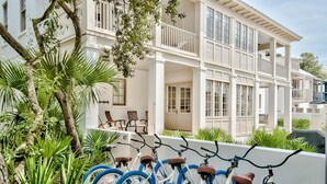 A row of bicycles with blue tires parked in front of a white building with balconies. - Access to Fitness Center and 4 Pools (Inlet Beach)