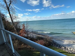 Une vue sur la côte, avec une balustrade, un rivage rocheux et une végétation clairsemée.