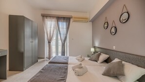 Une chambre d’hôtel moderne, dotée d’un grand lit, d’une armoire, d’un bureau et d’une fenêtre avec des rideaux.