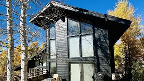 Une maison moderne dotée d’une terrasse, de grandes fenêtres et d’un garage.
