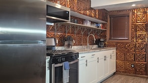 Una cocina moderna con electrodomésticos de acero inoxidable, armarios de madera y un salpicadero decorativo.