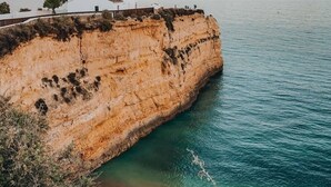 A coastal cliff with a white building on top, overlooking a calm sea. - A vacation not to be missed with an adult pool / a children's pool, close to the beach (Porches)