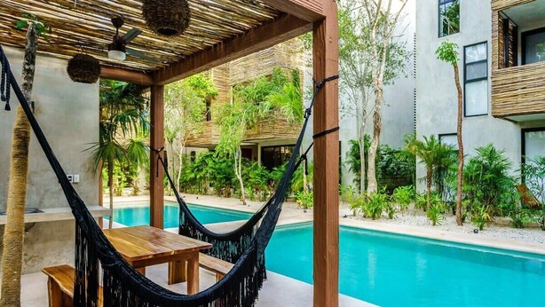 A hammock under a wooden pergola with a pool and greenery in the background. - Jungle-View Rooftop Retreat | La Veleta Sanctuary (Tulum)