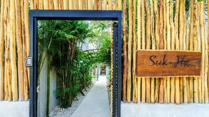 A bamboo-framed entrance to Suk-Ha Tulum with a pathway leading to a building. - Jungle-View Rooftop Retreat | La Veleta Sanctuary (Tulum)