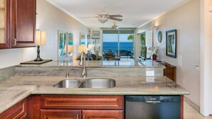 A kitchen with a double sink, wooden cabinets, and a Bosch dishwasher.
