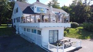 Une maison à deux étages dotée d’un balcon et d’une terrasse couverte.