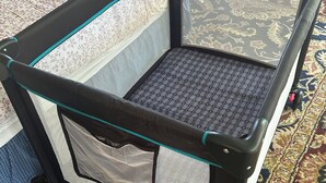 Une pièce comprenant un lit, une petite table, une armoire et un tapis à motifs.