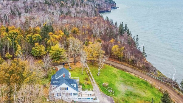 Une propriété située sur la côte, comprenant une grande maison, une allée et une pelouse.