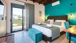 Ein modernes Schlafzimmer mit einem großen Bett, einer Bank, einem Tisch und Blick ins Freie.