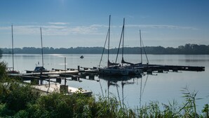 Een jachthaven met verschillende zeilboten afgemeerd aan houten steigers.