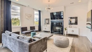 Ein modernes Wohnzimmer mit grauem Sofa, Couchtisch und Kamin.