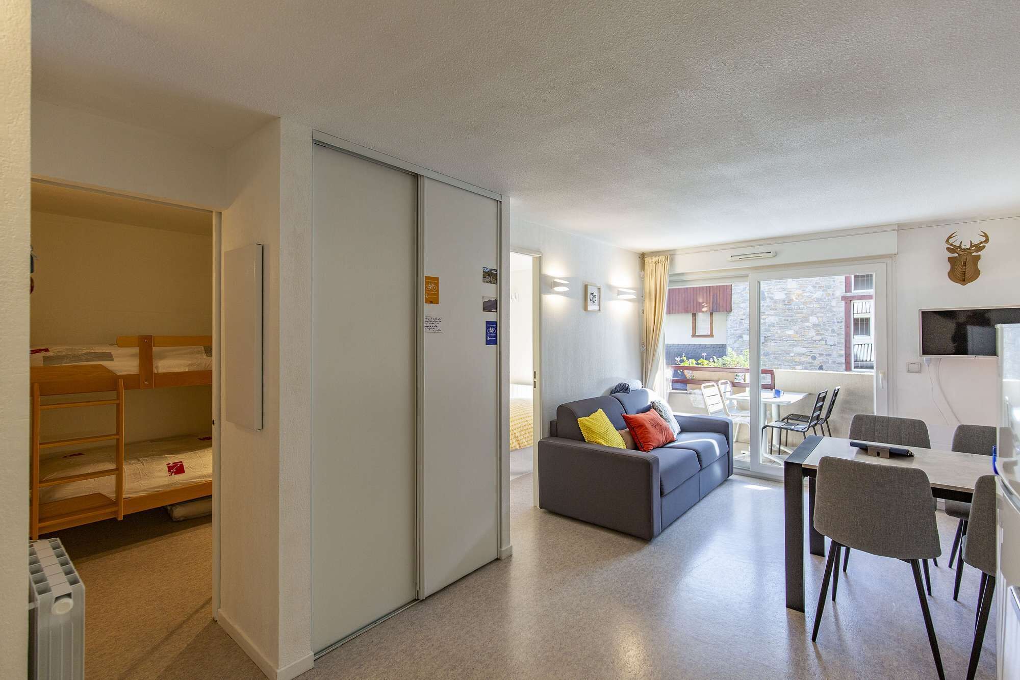 A compact living space with a sofa, a dining table, and a kitchenette.