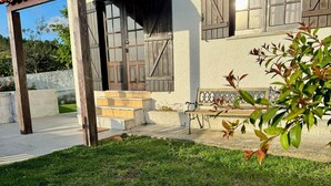 Una casa amb un porxo, una porta de fusta i una finestra amb persianes.
