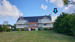 A two-story residential building with a flat roof, multiple balconies, and a well-maintained lawn in front. - Appartement Avec Terrasses, Équipements Entièrement Neufs (Crozon)