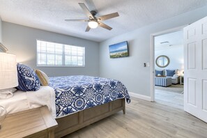 A bedroom with a bed, a ceiling fan, a window, and a door leading to another room. - The Pelican Villa | Large Pool + Firepit! (West Palm Beach)