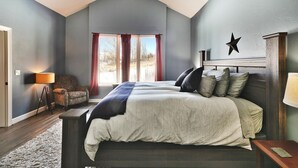 A bedroom with a large bed, a chair, a lamp, and a star decoration on the wall.