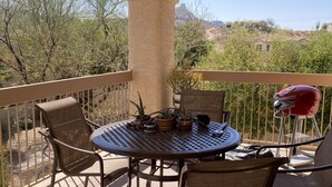 A covered outdoor patio with a round table and chairs, a ceiling fan, and a view of a mountainous landscape. - 2 bed 2 bath condo (Fountain Hills)