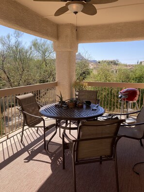 Enjoy a tranquil outdoor space with a round table and four chairs, surrounded by lush plants and a breathtaking mountain view.