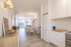 A modern kitchen with white cabinets, a wooden countertop, and a built-in oven.