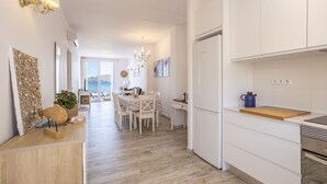 Une cuisine moderne avec des armoires blanches, un plan de travail en bois et un four encastré.