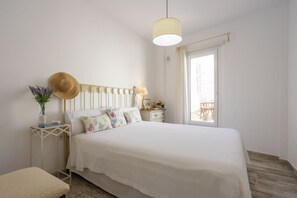 A neatly arranged bedroom with a bed, bedside table, and a window with a view.