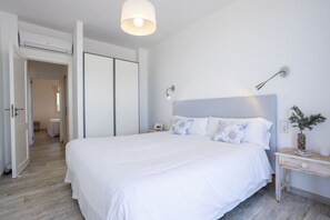 Ein ordentlich eingerichtetes Schlafzimmer mit einem großen Bett, Nachttischen und einem Beistelltisch.