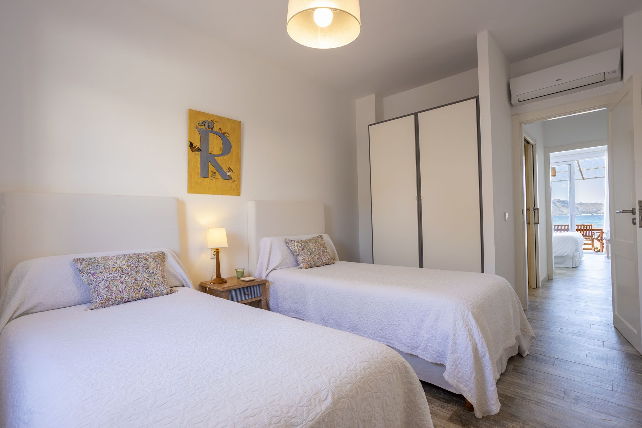Ett hotellrum med två sängar, en garderob och utsikt över balkongen.