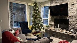 A cozy living room with a fireplace, a Christmas tree, and a comfortable sofa. - Entire 4-bedroom house, billiards and ping-pong, close to University of Oregon (Eugene)